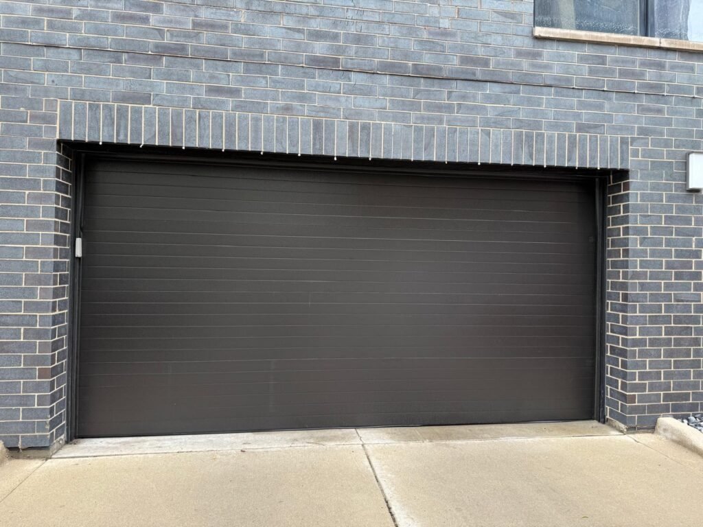 New dark charcoal garage door installed on a Chicago brick home by Fairway Garage Door