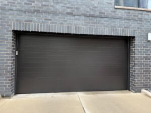 New dark charcoal garage door installed on a Chicago brick home by Fairway Garage Door